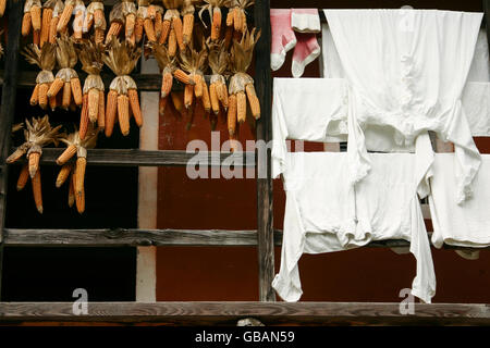 Un balcon d'une ancienne ferme dans le musée en plein air du Ballenberg en Suisse avec le maïs sec et blanchisserie blanc Banque D'Images