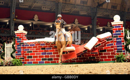 Robert Whitaker, de Grande-Bretagne, de Finbarr V, s'écrase sur le mur de l'Accenture Christmas puissance lors du London International Horse Show à Olympia, Londres. Banque D'Images