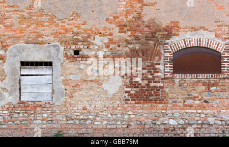 Mur de bâtiment abandonné avec de brique rouge et de l'embarqué-up Banque D'Images