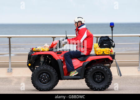 Lifeguard la conduite d'un quad de patrouille de plage le long de la promenade de Blackpool, lancashire, uk Banque D'Images