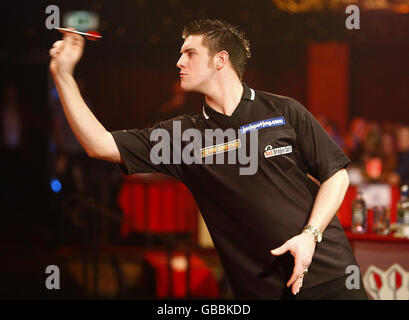 Daryl Gurney en Irlande du Nord en action contre Martin Adams en Angleterre pendant le Championnat du monde des fléchettes à Frimley Green, Surrey. Banque D'Images