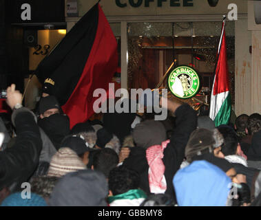 Les fenêtres d'une succursale de café Starbucks sont écrasées lors d'une manifestation contre le conflit à Gaza près de l'ambassade israélienne à Londres. Banque D'Images