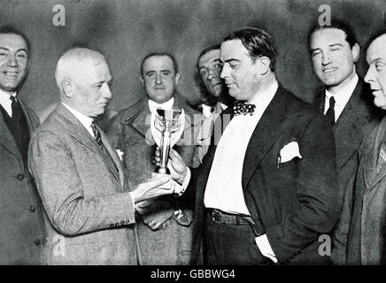 (G-D) le Président de la FIFA, Jules Rimet, présente la coupe du monde au Dr Paul Jude, Président de l'Association uruguayenne de football, après la victoire de son équipe en 4-2 dans la finale Banque D'Images