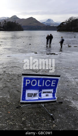 Derwentwater près de Keswick solide gelé avec un panneau d'avertissement de police glace aujourd'hui que le sort de froid continue. Banque D'Images