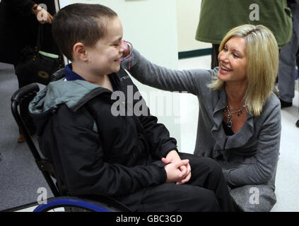 Olivia Newton-John discute avec le malade du cancer Liam Fairhurst, 13 ans, de Soham, Cambridgeshire, lors d'une visite au département d'oncologie de l'hôpital Addembrooke de Cambridge, Cambridgeshire. Banque D'Images