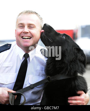 PC Simon Jeffrey avec le chien de police Vader, qui est tombé près de 40 pieds tout en poursuivant un suspect, au poste de police de Keighley. Banque D'Images