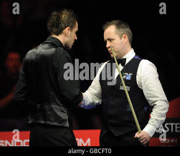 Mark Selby (à gauche) serre la main avec John Higgins pendant les Masters à Wembley Arena, Londres. Banque D'Images