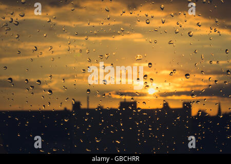 Gouttes de pluie sur la fenêtre , fond de ciel coucher de soleil Banque D'Images