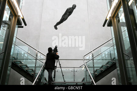 Un homme filme une sculpture Antony Gormley, Filter (2002), qui vient d'être exposée à la Manchester City Art Gallery. Banque D'Images