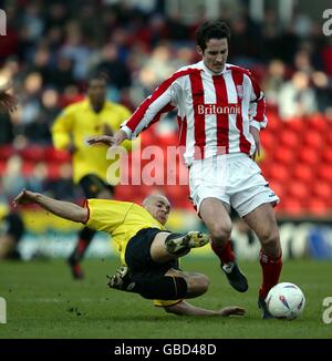 Gavin Mahon de Watford (l) glisse pour s'attaquer à Stoke City Clive Clarke (r) Banque D'Images