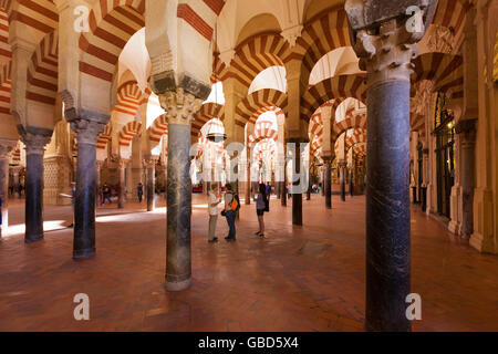 Les visiteurs ci-dessous les arches à l'intérieur de l'Mosque-Cathedral de Cordoue, Espagne Banque D'Images