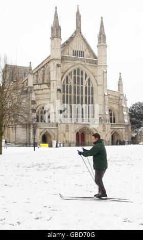 Alex Wardle se dirige vers la cathédrale de Winchester à bord de skis après de fortes chutes de neige. Banque D'Images