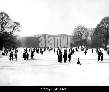À l'ombre du palais de Buckingham, les patineurs et les glisseurs emmènent sur la glace du lac gelé du parc St. James. Banque D'Images