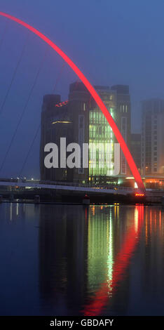 Le brouillard roule au-dessus du pont du millénaire à Newcastle qui a été illuminé en rouge pour Comic relief pour marquer le lancement de la Journée du nez rouge de cette année. Banque D'Images