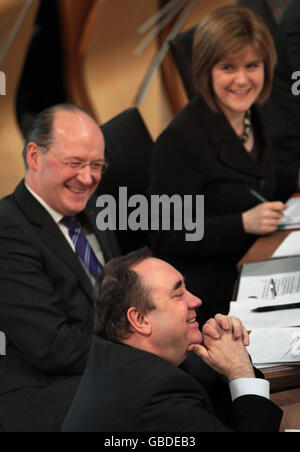 Le premier ministre Alex Salmond (en bas) sourit avec le secrétaire aux finances du parti national écossais John Swinney (au centre) et le chef adjoint Nicola Sturgeon (en haut) lors du débat sur le budget au Parlement écossais, à Édimbourg. Banque D'Images