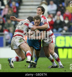 Oliver Wilkes de Wakefield est affronté par Phil Bailey de Wigan et Sean O'Loughlin lors du match de la Super League engage au JJB Stadium, Wigan. Banque D'Images