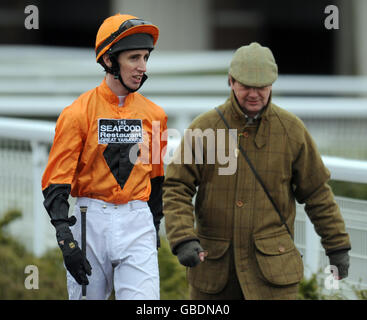 Le jockey George Baker parle avec l'entraîneur Chris Wall avant de monter à Premio Loco dans les piquets Ladybird (classe 1) à l'hippodrome de Kempton Park, Surrey Banque D'Images