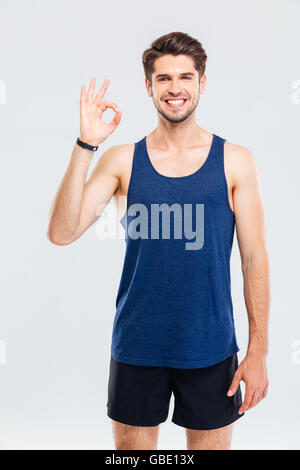 Close-up portrait of a man fitness okay sign isolé sur fond gris Banque D'Images