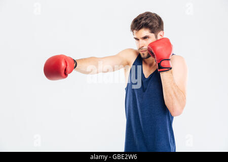 Portrait d'un jeune homme sportif de boxe gants rouge isolé sur fond gris Banque D'Images