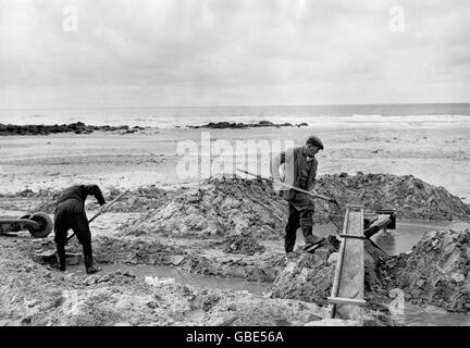 Travailleurs britanniques - Tin-Panners - Porthtoran - 1952.Des hommes se sont mis à chercher de l'étain sur la plage de Porthtopan, dans les Cornouailles. Banque D'Images