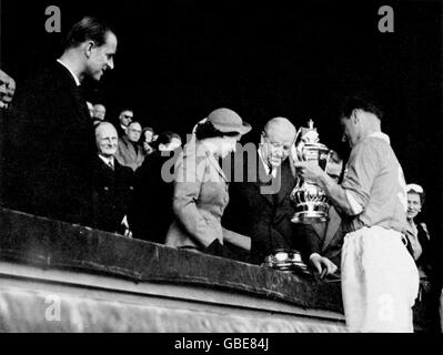 HRH la reine Elizabeth II (c) présente la coupe FA au capitaine gagnant, Harry Johnston (r) de Blackpool, sous la surveillance de HRH le duc d'Édimbourg (l) et du président de la FA, Stanley Rous (deuxième r) Banque D'Images