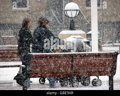 Temps d'hiver. Les gens brave la neige dans le centre-ville de Newcastle. Banque D'Images