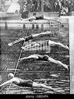 Les nageurs plongent dans la piscine (en haut) : Johnny Weissmuller aux États-Unis, Arne Borg en Suède, Andrew Charlton en Australie, Ake Borg en Suède, John Hatfield en Grande-Bretagne. Le légendaire Weissmuller, qui allait à la renommée du cinéma comme Tarzan, a remporté la médaille d'or dans cet événement. Banque D'Images