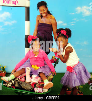 Jamelia et ses deux filles, Teja (8 ans), Tiani (3 ans), creusent leurs vieilles chaussures pour la nouvelle campagne de Brantano. Banque D'Images