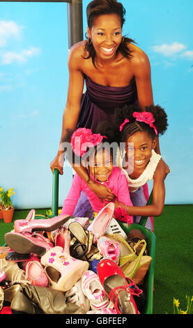 Jamelia et ses deux filles, Teja (8) , Tiani (3) creusent leurs vieilles chaussures pour la nouvelle campagne de Brantano. Banque D'Images