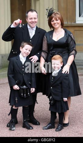 Le joueur de snooker John Higgins, avec son épouse Denise et deux de leurs enfants Pierce, Oliver, de sept et quatre ans, au Palais de Buckingham après avoir reçu le MBE de la Princesse Royale. Banque D'Images