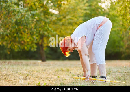 Active senior woman doing gymnastics avec un cerceau en été Banque D'Images