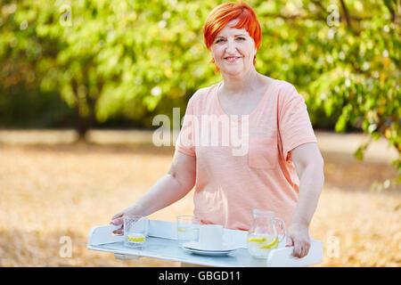 Femme tenant un verre de rafraîchissement sur une tablette pendant ses vacances d'été Banque D'Images