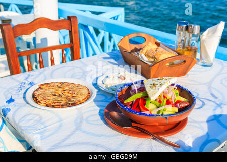 L'île de Samos, Grèce - Sep 20, 2015 : salade grecque sur table dans une taverne traditionnelle avec l'eau de mer bleue en arrière-plan on Samos Island Banque D'Images