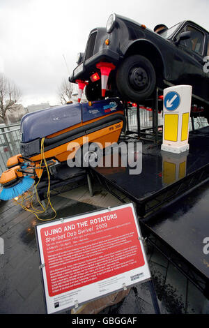 'herbet DAB Swivel' une sculpture faite d'un taxi noir, balai de route et travaux de roadworks créés par Ujino et les Rotators, exposés le long de la Southbank à Londres. Banque D'Images