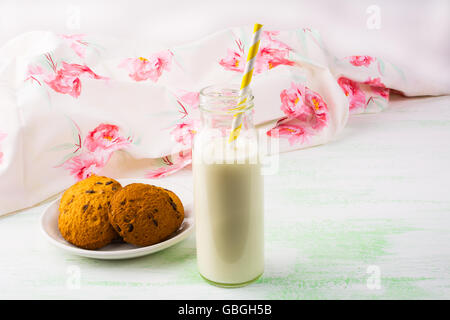 Bouteille de lait et des biscuits avec de la paille. Le petit-déjeuner les cookies. Pâtisseries sucrées. Dessert sucré. Cookies faits maison Banque D'Images