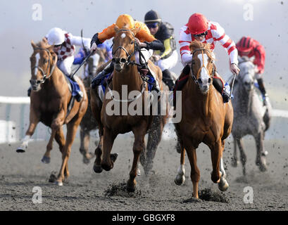 Scintillo, monté par Richard Hughes (à droite), remporte le Derby d'hiver sportingbet.com de Premio Loco, monté par George Baker (orange) pendant la journée du Derby d'hiver à l'hippodrome de Linfield. Banque D'Images