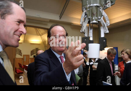 Quentin Davies (au centre), ministre de l'équipement et du soutien de la défense, étudie le véhicule sans pilote Northrop Grumman conçu pour l'élimination à distance d'engins explosifs improvisés et d'autres fonctions lors d'un événement de la semaine nationale des sciences et de l'ingénierie à Armoury House à Londres. Banque D'Images