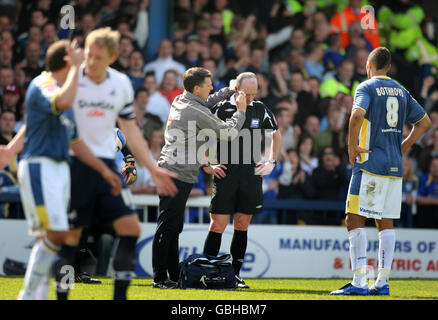 Football - Coca-Cola Championship - Cardiff City / Swansea City - Ninian Park.L'arbitre Mike Dean est aidé par un phyiso après avoir été frappé par une pièce de monnaie lors du match de championnat Coca-Cola à Ninian Park, Cardiff. Banque D'Images