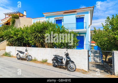 Deux scooters en stationnement sur rue en face de maisons typiquement grec, l'île de Samos, Grèce Banque D'Images