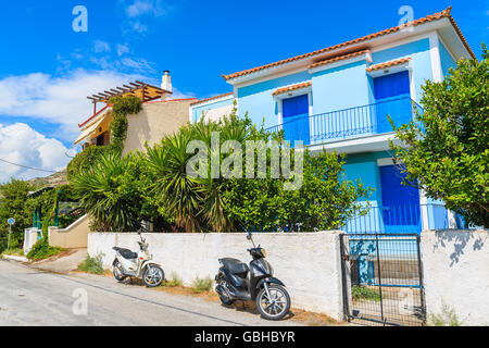 Deux scooters en stationnement sur rue en face de maisons typiquement grec, l'île de Samos, Grèce Banque D'Images