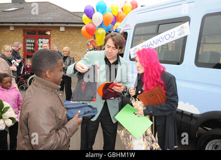 Jonathan Ross et sa femme Jane présentent un entraîneur du Club des variétés Sunshine à la Trinity School de Dagenham, Essex. Banque D'Images