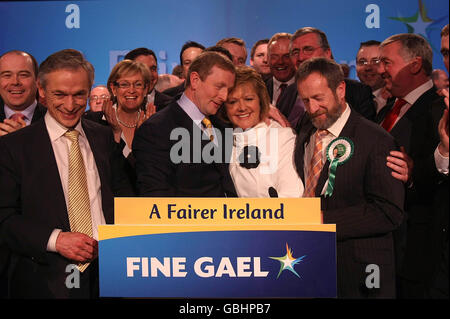 Le chef de fine Gael Enda Kenny avec son épouse Fionnuala et le chef adjoint Richard Bruton (à gauche), après avoir prononcé son discours présidentiel à l'hôtel Citywest de Dublin. Banque D'Images