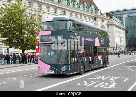 Un nouveau Routemaster bus à Londres Marylebone avec rose et noir publicité Magnum plus de lecteurs de Westminster Bridge London, UK Banque D'Images