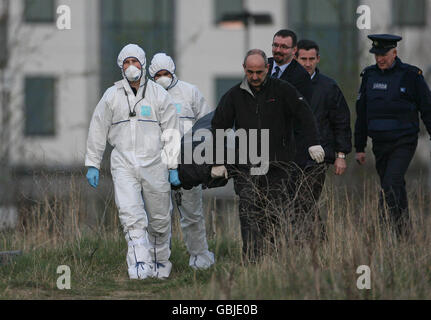 Les enquêteurs des lieux de crime retirent le corps d'un homme qu'on croyait être à la fin de la vingtaine, qui a été découvert au large de Belcamp Lane, Coolock, au nord de Dublin, vers 16h par un passant. Banque D'Images