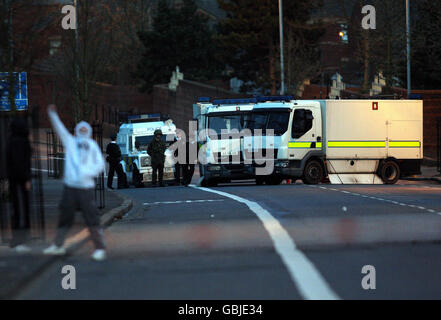 Des experts de l'armée surveillent une fourgonnette abandonnée et brûlée sur la route Crumlin à Belfast. Banque D'Images