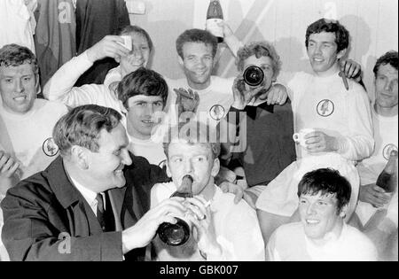 Les joueurs de Leeds United fêtent avec du champagne et des cigares dans le dressing après avoir dessiné 0-0 avec Liverpool, un résultat qui a conclu le premier titre de championnat de la division 1 de Leeds : (rangée arrière, l-r) Mick Jones, Jack Charlton, Paul Reaney, Gary Spake, Johnny Giles, Paul Madeley ; (Première rangée, l-r) gérant Don Revie, Peter Lorimer, Billy Bremner, Eddie Gray Banque D'Images