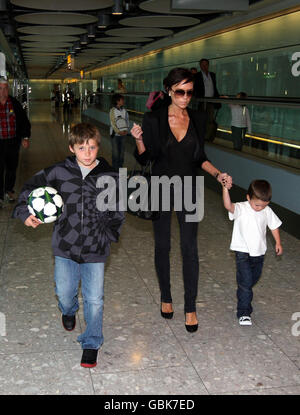 Victoria Beckham arrive de Milan au terminal 5 de l'aéroport d'Heathrow, Middlesex, avec ses fils Brookyn (à gauche), Romeo (non représenté) et Cruz. Banque D'Images