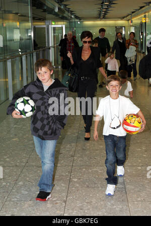 Victoria Beckham arrive de Milan au terminal 5 de l'aéroport de Heathrow, Middlesex, avec ses fils Brookyn (à gauche), Romeo (à droite) et Cruz. Banque D'Images