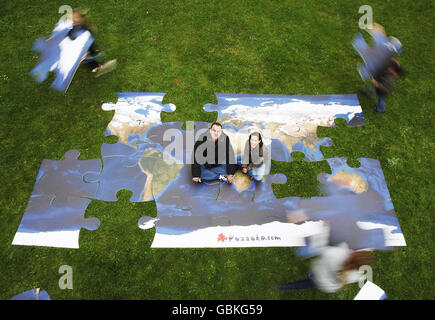 Andre van Rensburg, à gauche, et Joelle Kuster, fondateurs de Puzzuka, le plus grand puzzle en ligne au monde, se trouvent au centre d'un puzzle géant pour le lancement du site, à Southwark Park, au sud de Londres. Banque D'Images
