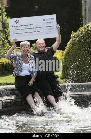 Martyn et Sandra White de Luton, éclabousser leurs pieds dans l'étang de l'hôtel Luton Hoo pendant qu'ils célèbrent leur gain de 10.7 millions de Loterie nationale qui a été annoncé aujourd'hui. Banque D'Images